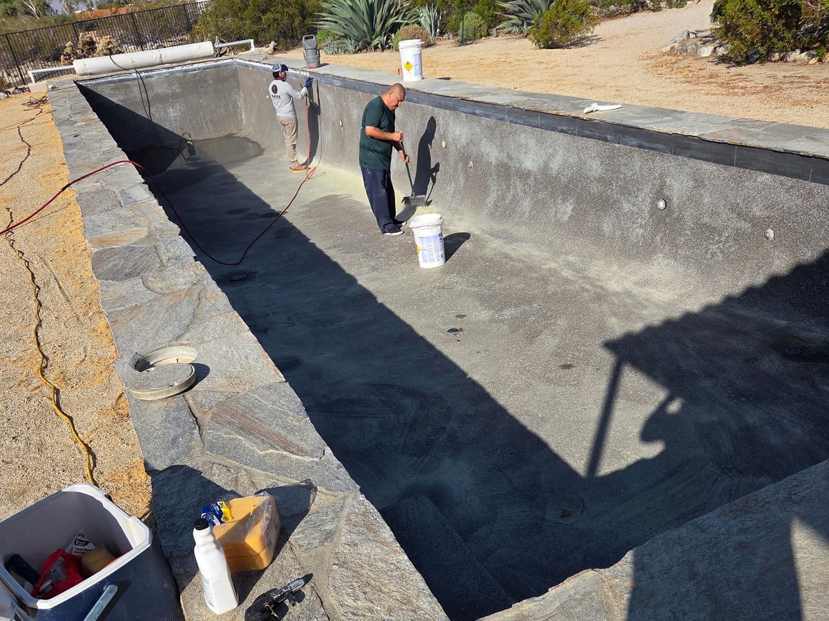 Crew re-plastering a drained swimming pool in the Coachella Valley