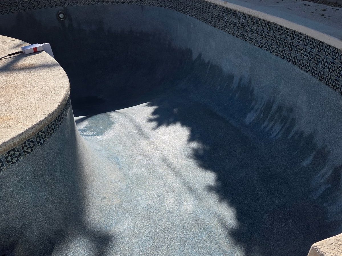 Drained pool showing a clean decorative waterline tile band serviced by Aqua Fresh Pool Service
